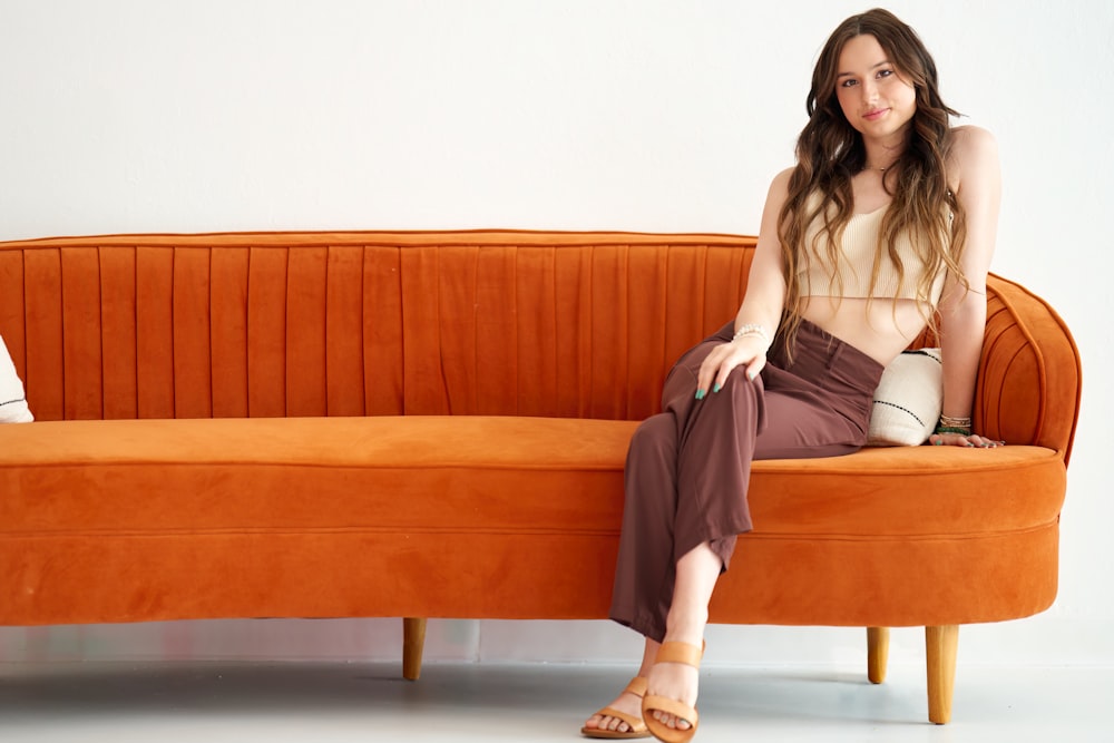 a woman sitting on top of a couch next to a man