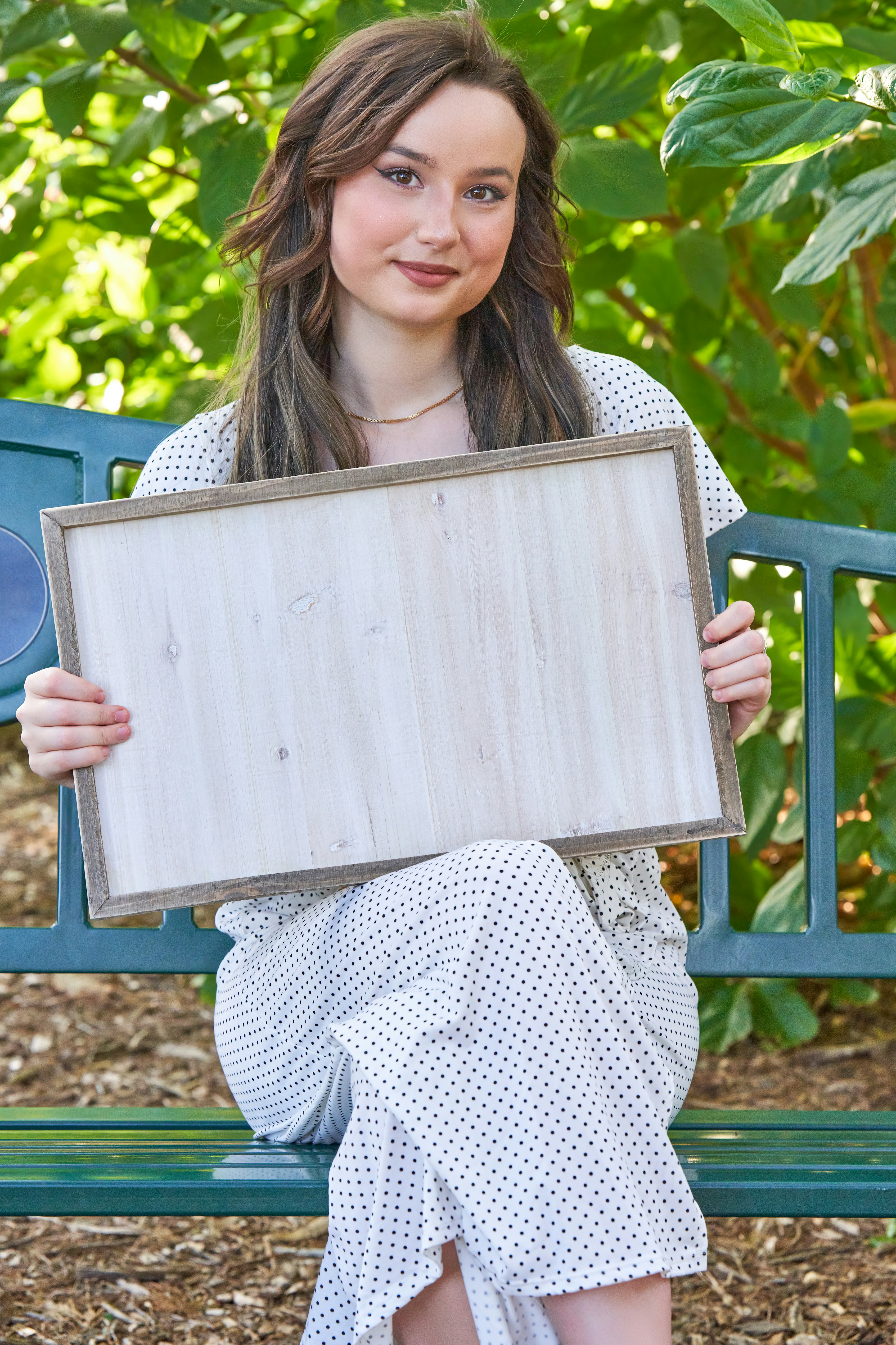 a woman sitting on a bench holding a sign