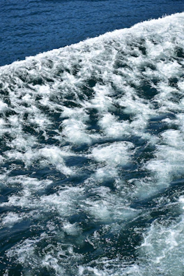 A dynamic live wallpaper app showing animated waves in deep blue hues.