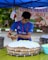 a man in a blue shirt putting icing on a cake
