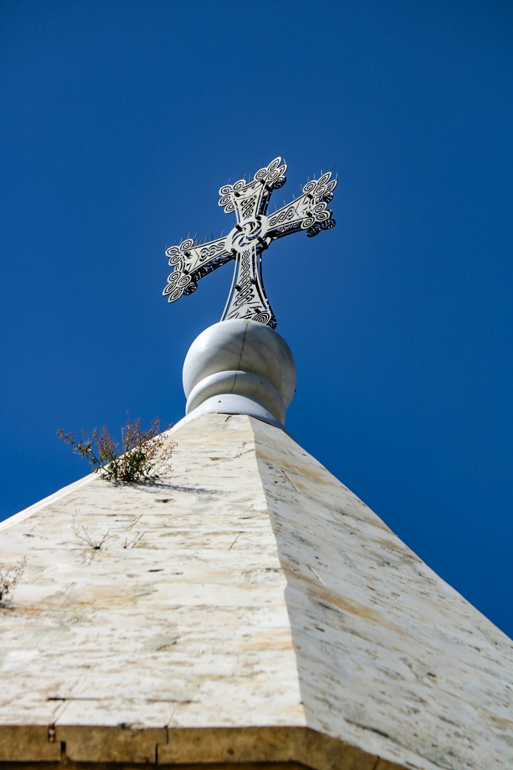 a cross on top of a building with a blue sky in the background