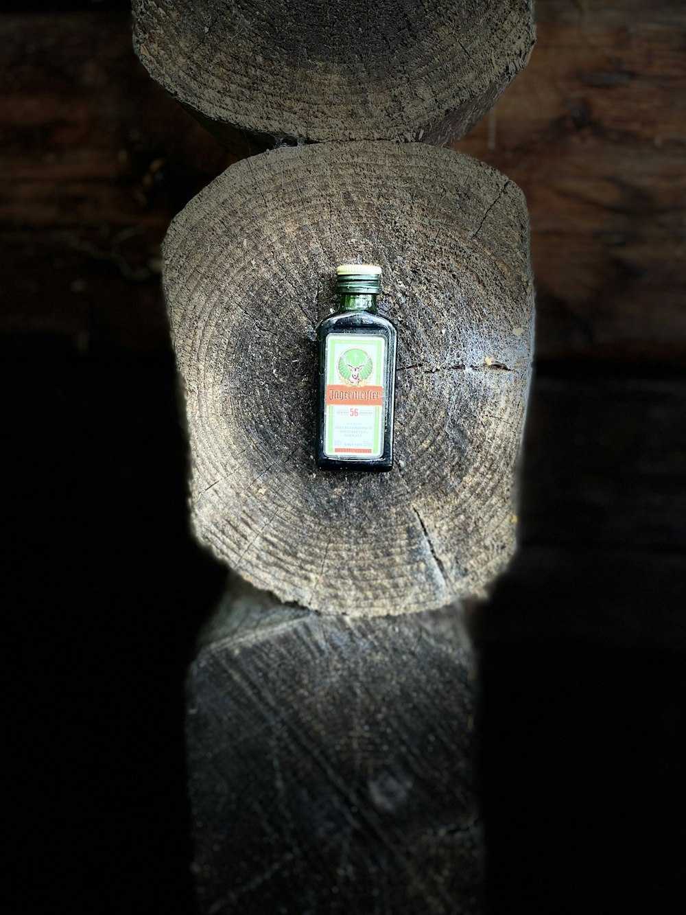 a small bottle sitting on top of a piece of wood