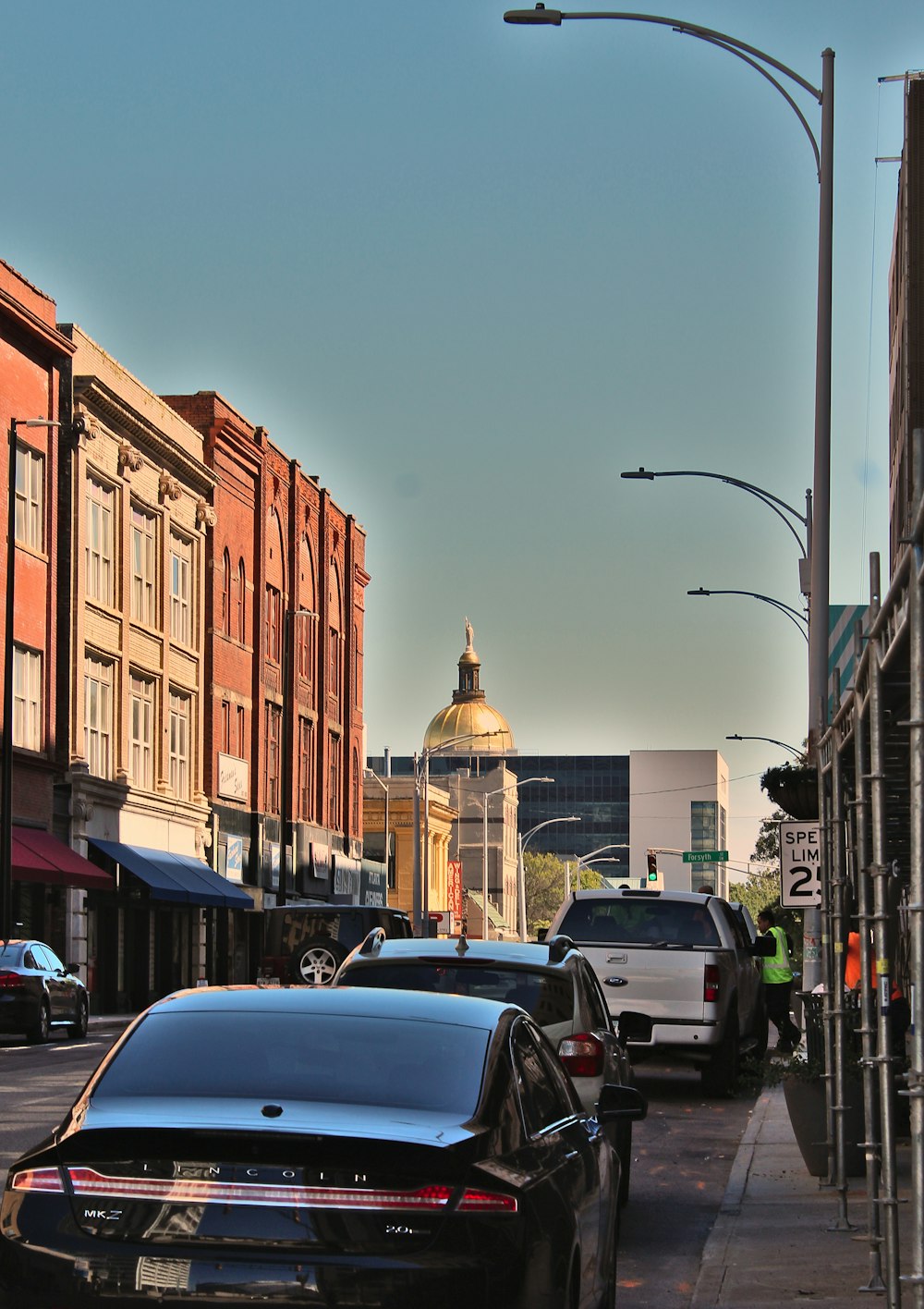 a city street filled with lots of traffic next to tall buildings