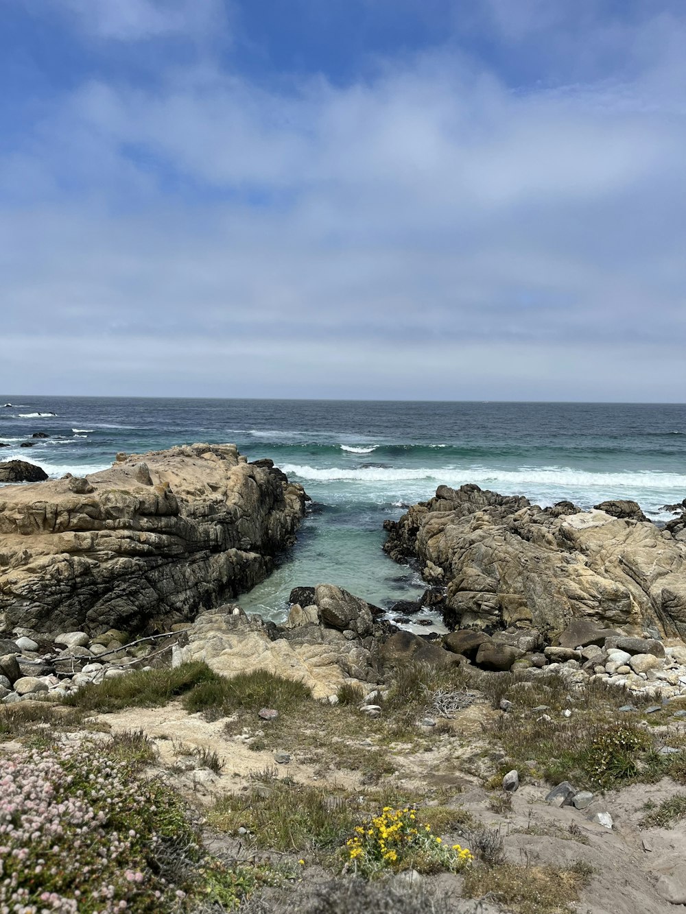 a view of the ocean from a rocky shore