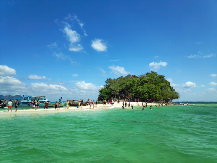 A vibrant beach scene in Punta Cana with turquoise waters and tourists enjoying a boat tour.