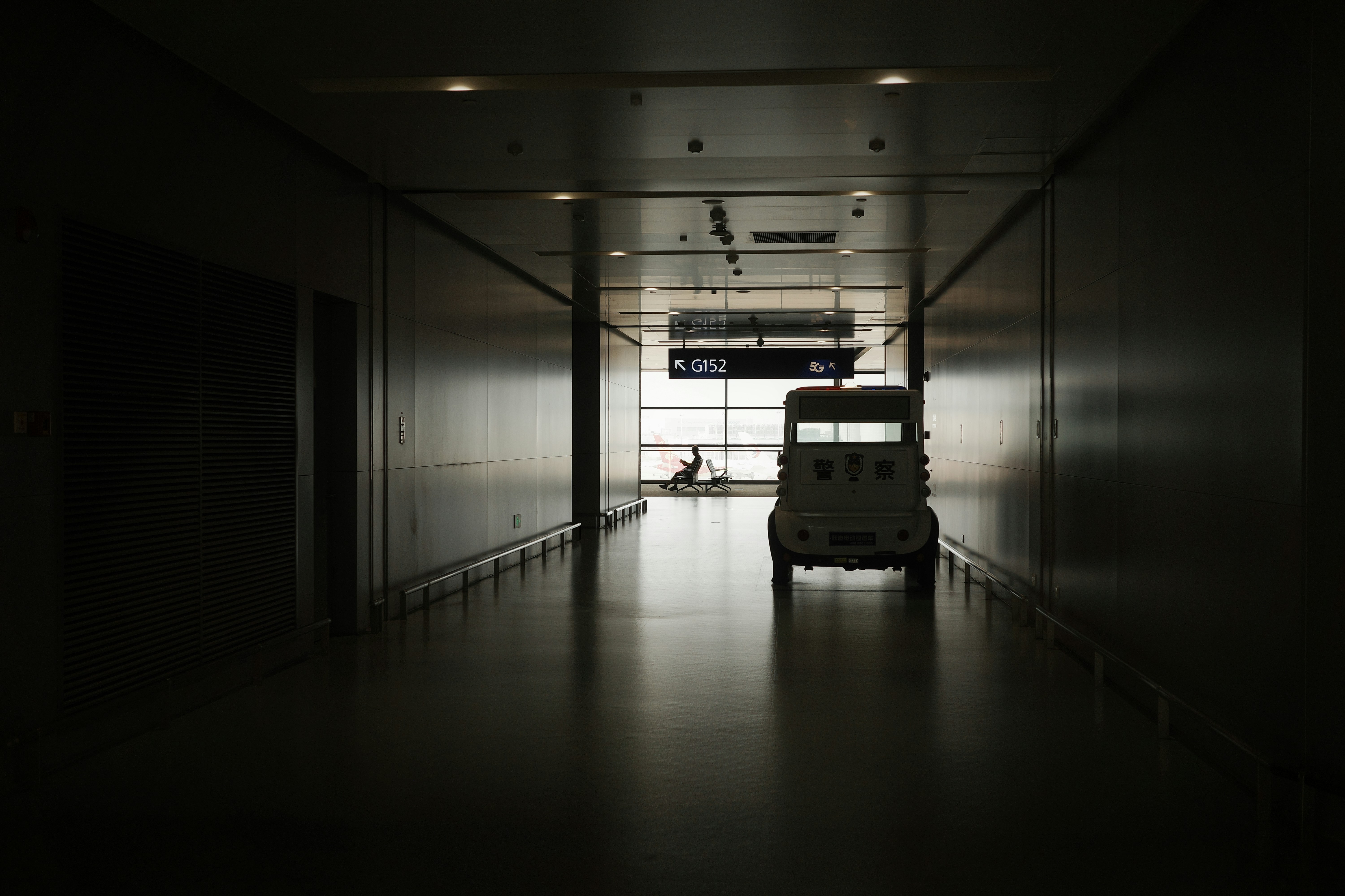 a suitcase sitting in the middle of a dark hallway, 