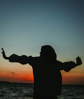 a man standing on a beach holding a frisbee