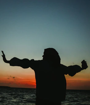 a man standing on a beach holding a frisbee