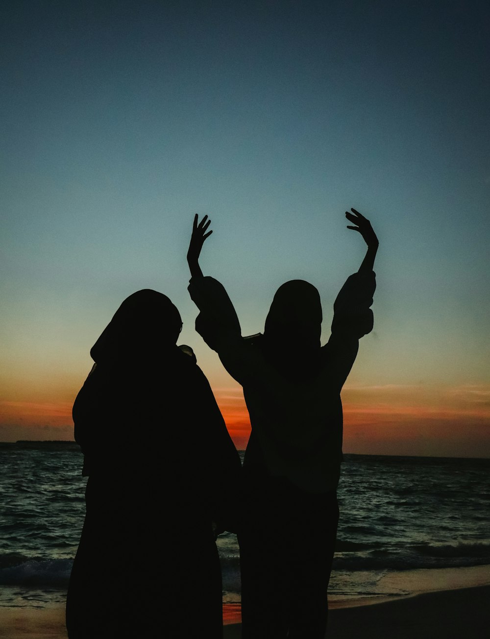 a couple of people that are standing in the sand