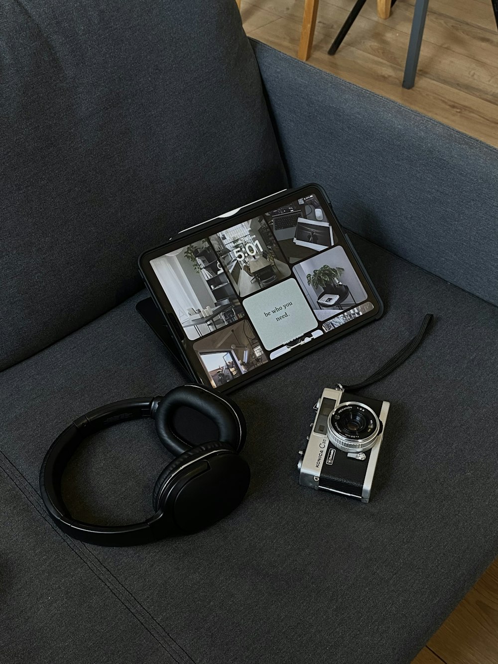 a camera, headphones, and a tablet on a couch