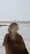 a woman standing on top of a beach next to the ocean