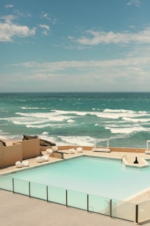 An inviting poolside view of a modern beachfront apartment.