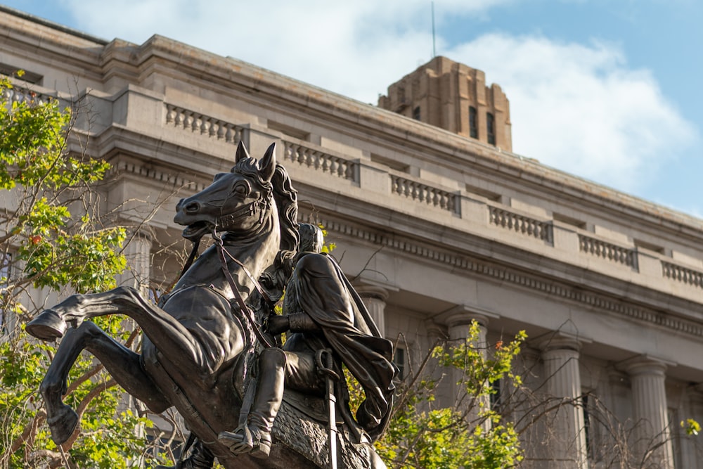 a statue of a man riding a horse in front of a building