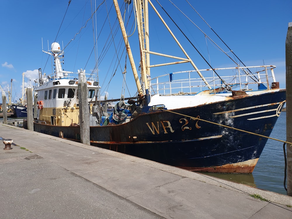 a boat docked at a dock with a dog nearby