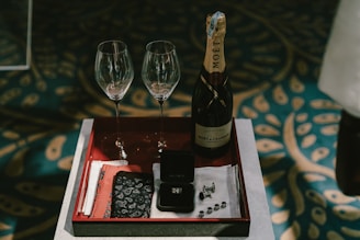 a tray with two wine glasses and a bottle of wine