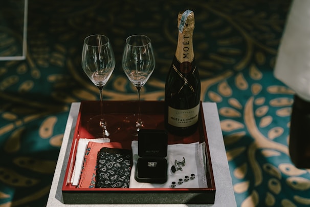 a tray with two wine glasses and a bottle of wine
