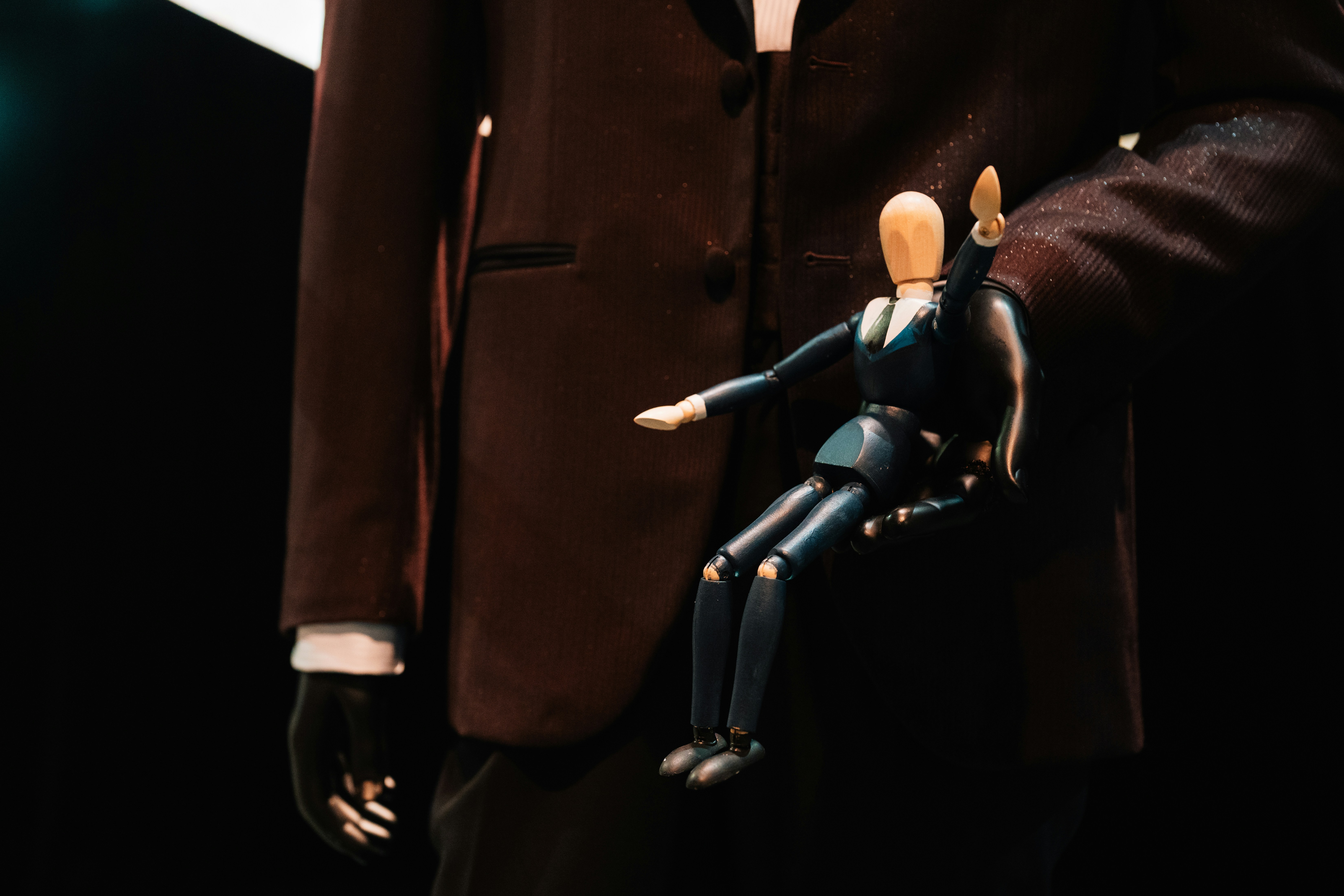Un homme en costume et cravate tenant une poupée