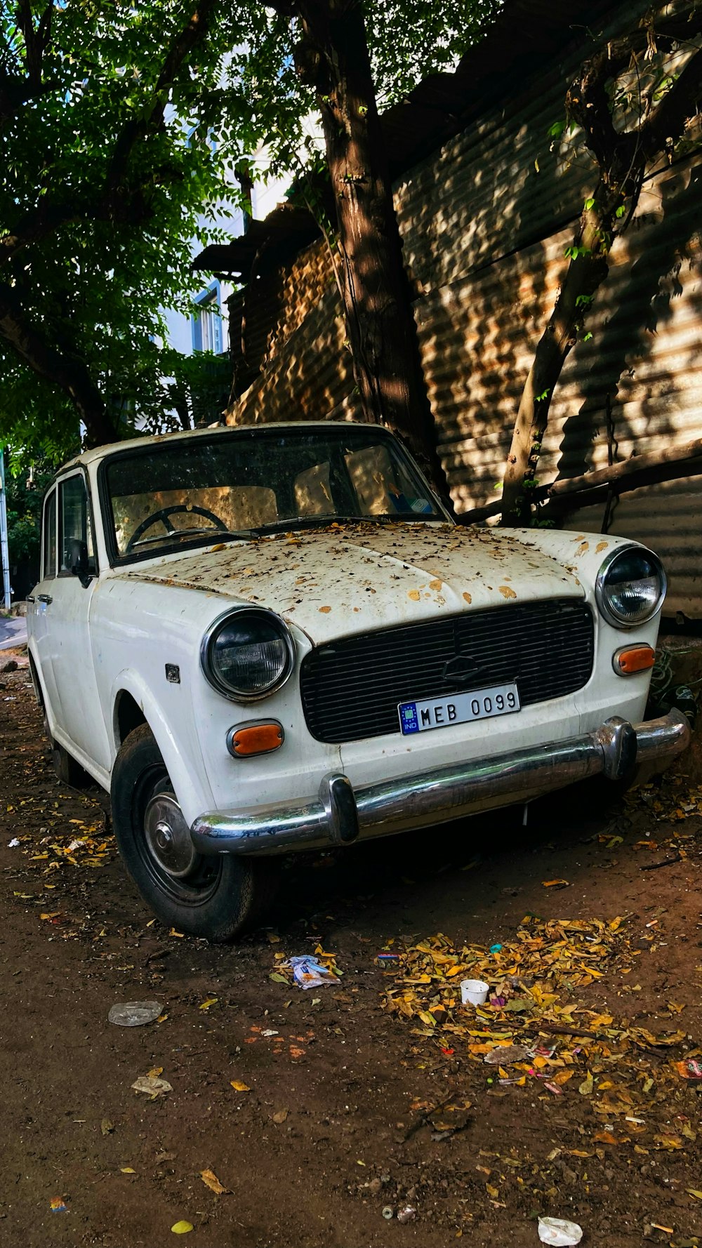 an old white car parked on the side of the road