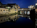 Night view of Bucharest’s illuminated monuments reflecting in a calm river