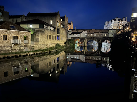Night view of Bucharest’s illuminated monuments reflecting in a calm river