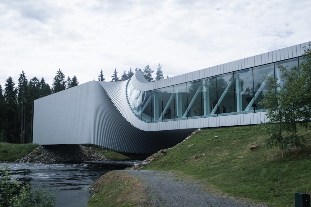 a white building with a curved roof next to a river