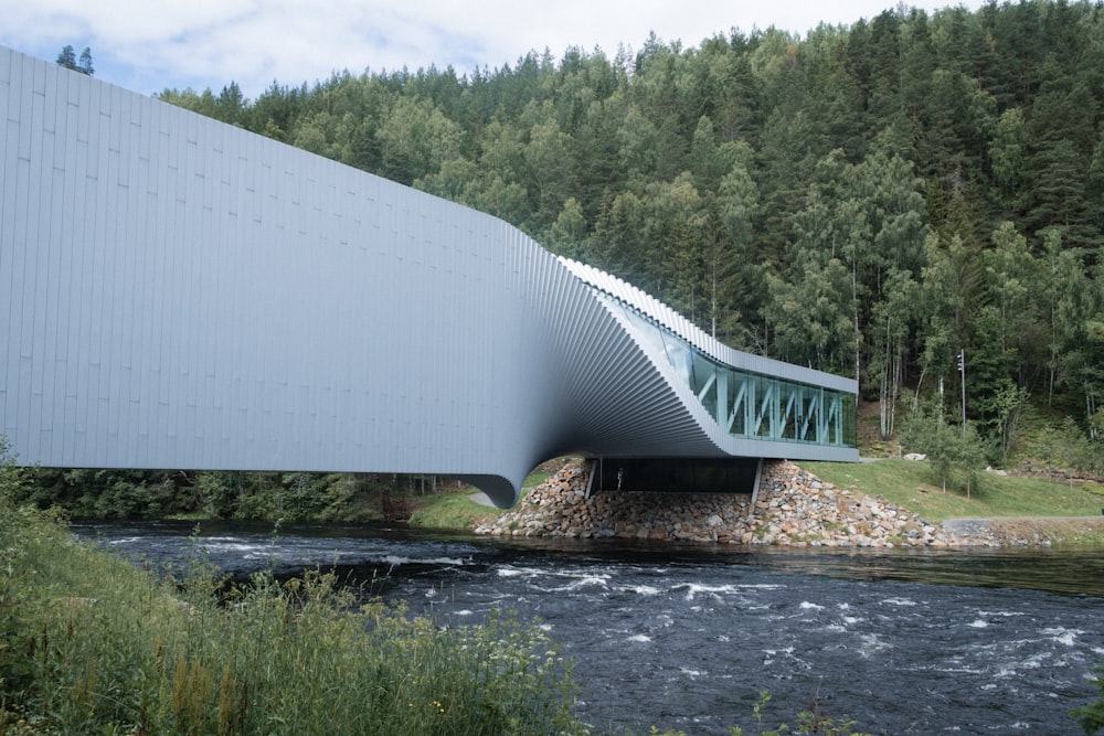 a large bridge over a river next to a forest