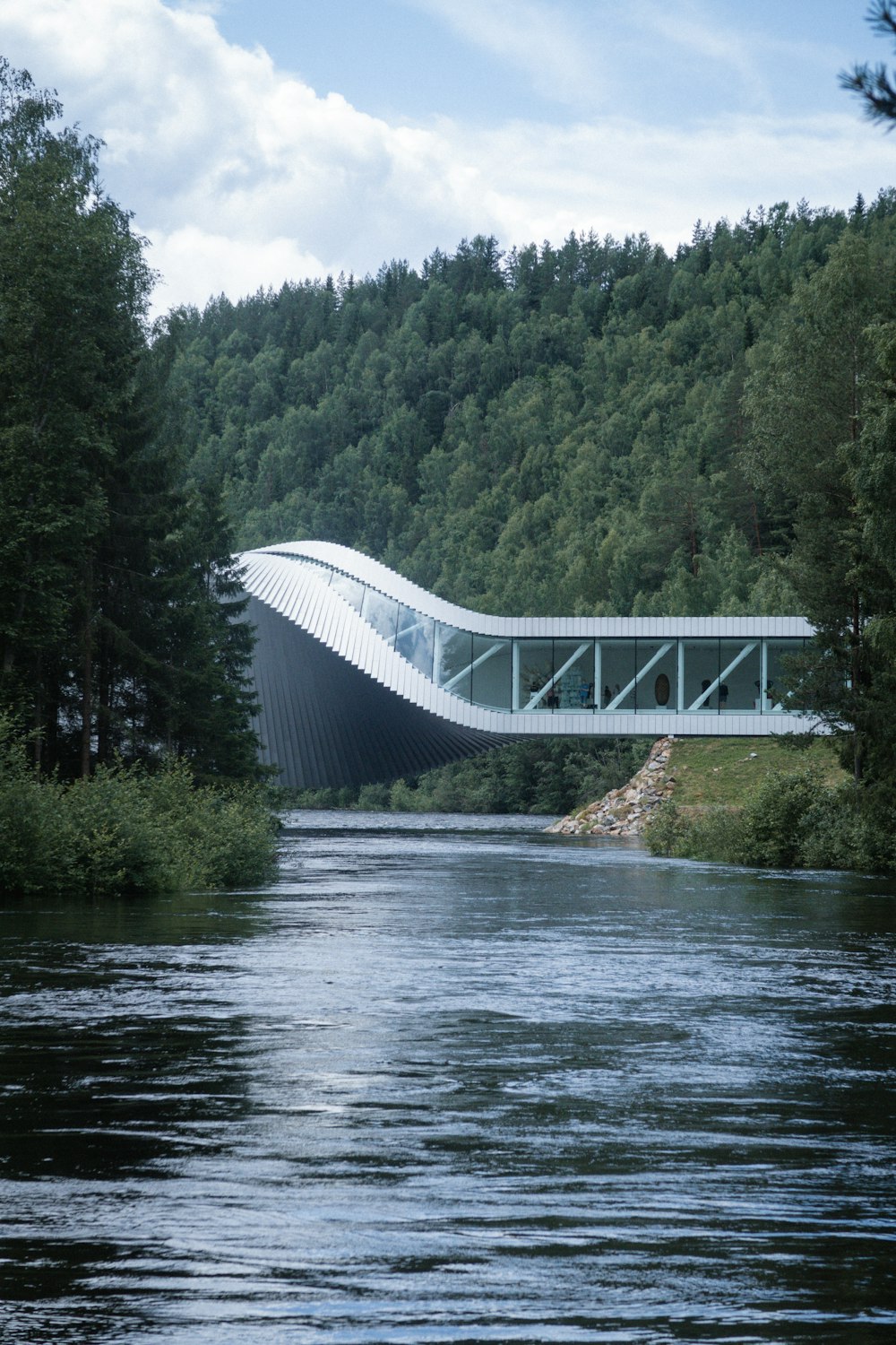 a bridge over a body of water with trees in the background