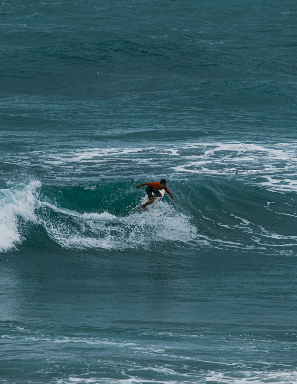 a man riding a wave on top of a surfboard