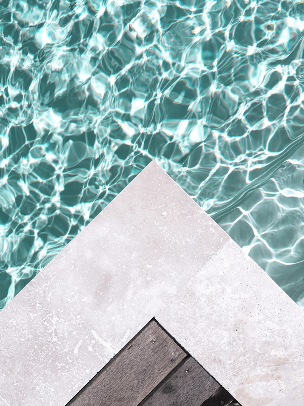 an umbrella sitting on top of a wooden dock next to a body of water