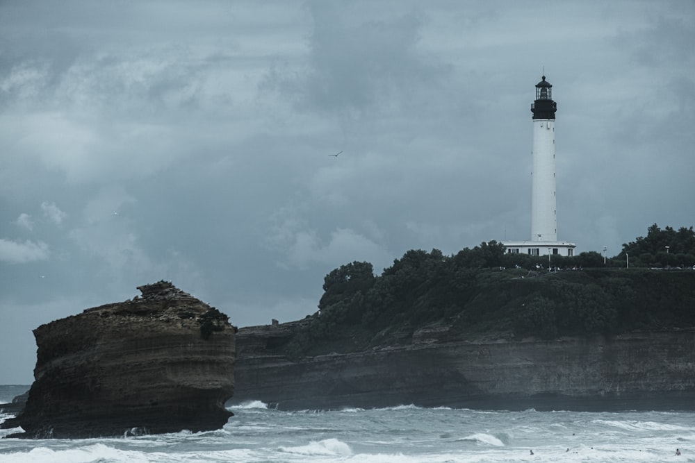 a light house sitting on top of a cliff next to the ocean