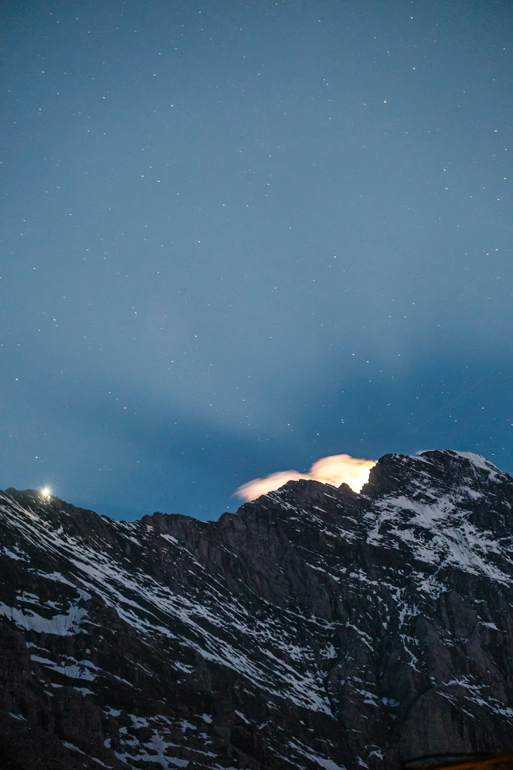 the night sky over a snowy mountain range