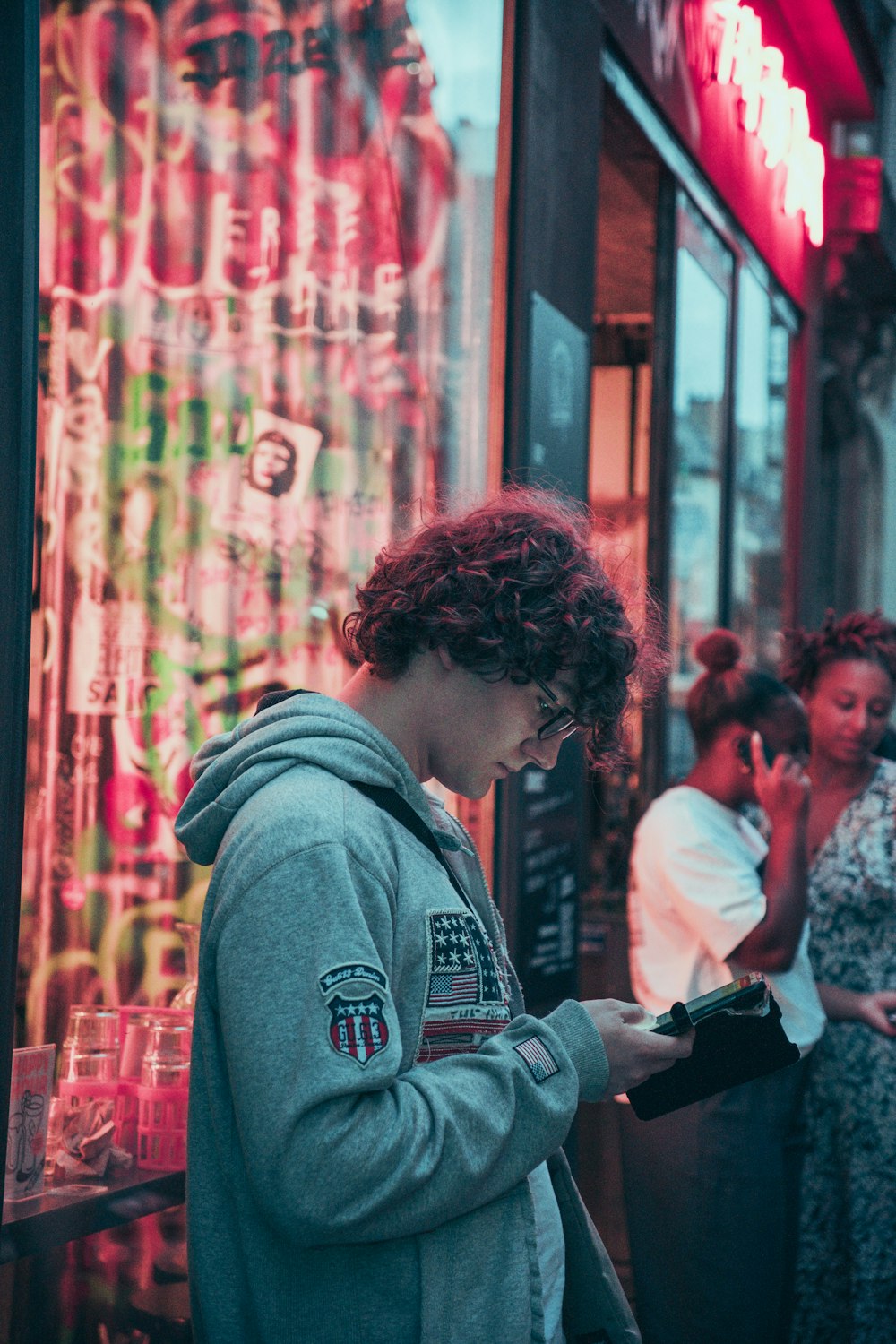 a woman standing in front of a store looking at her phone