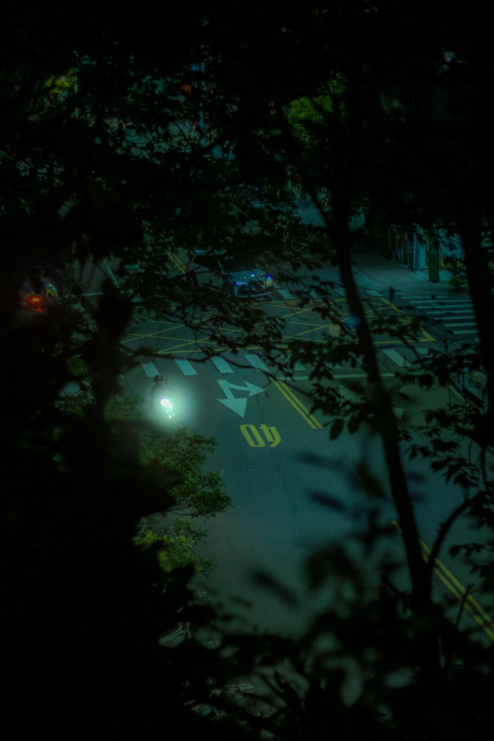 a street at night with cars driving on it