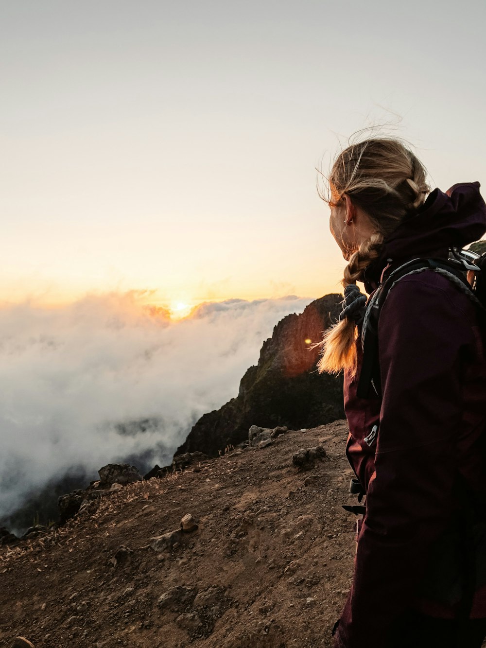 a woman standing on top of a mountain with a backpack