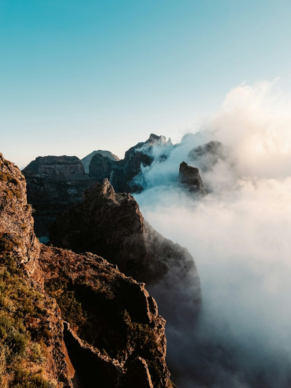 a person standing on top of a mountain surrounded by clouds