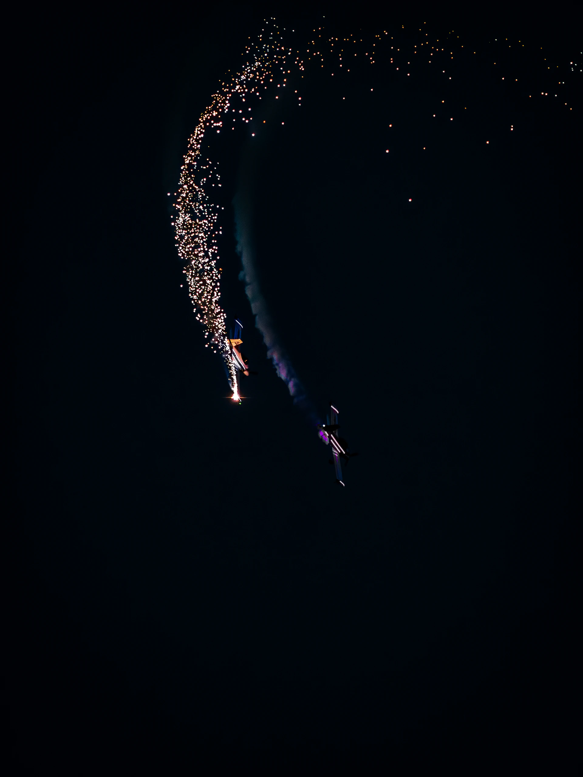 Close-up of the sleek darkstar l39 Albatros performing a tight aerobatic roll against a dramatic dusk sky.