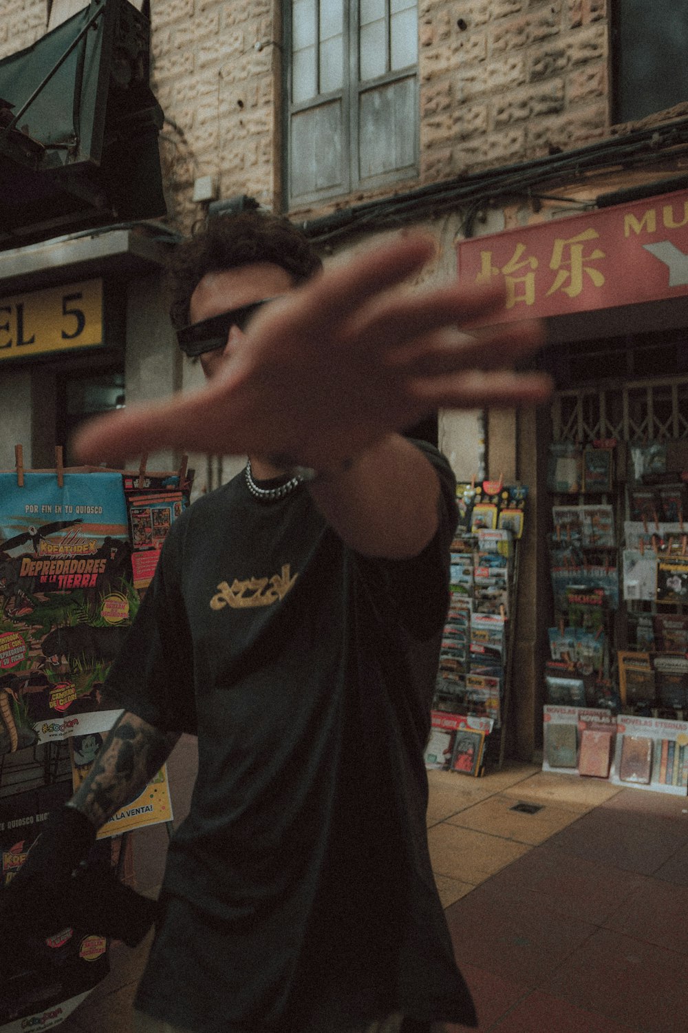 a man standing in front of a store holding his hand out