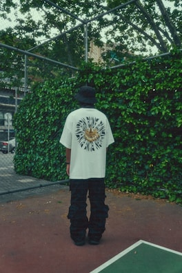A basketball-inspired graphic tee hanging against a brick wall.