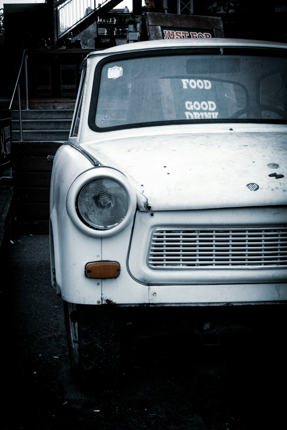 an old white car parked on the side of the road