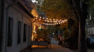 Evening lights casting a warm glow over the outdoor dining area surrounded by nature.