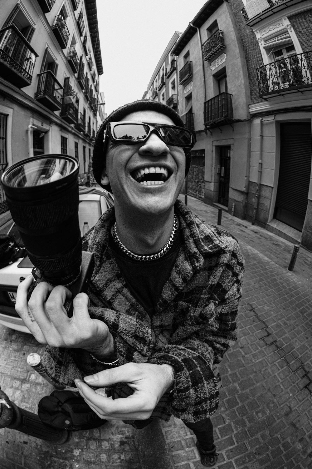 a man with a hat and glasses holding a coffee cup