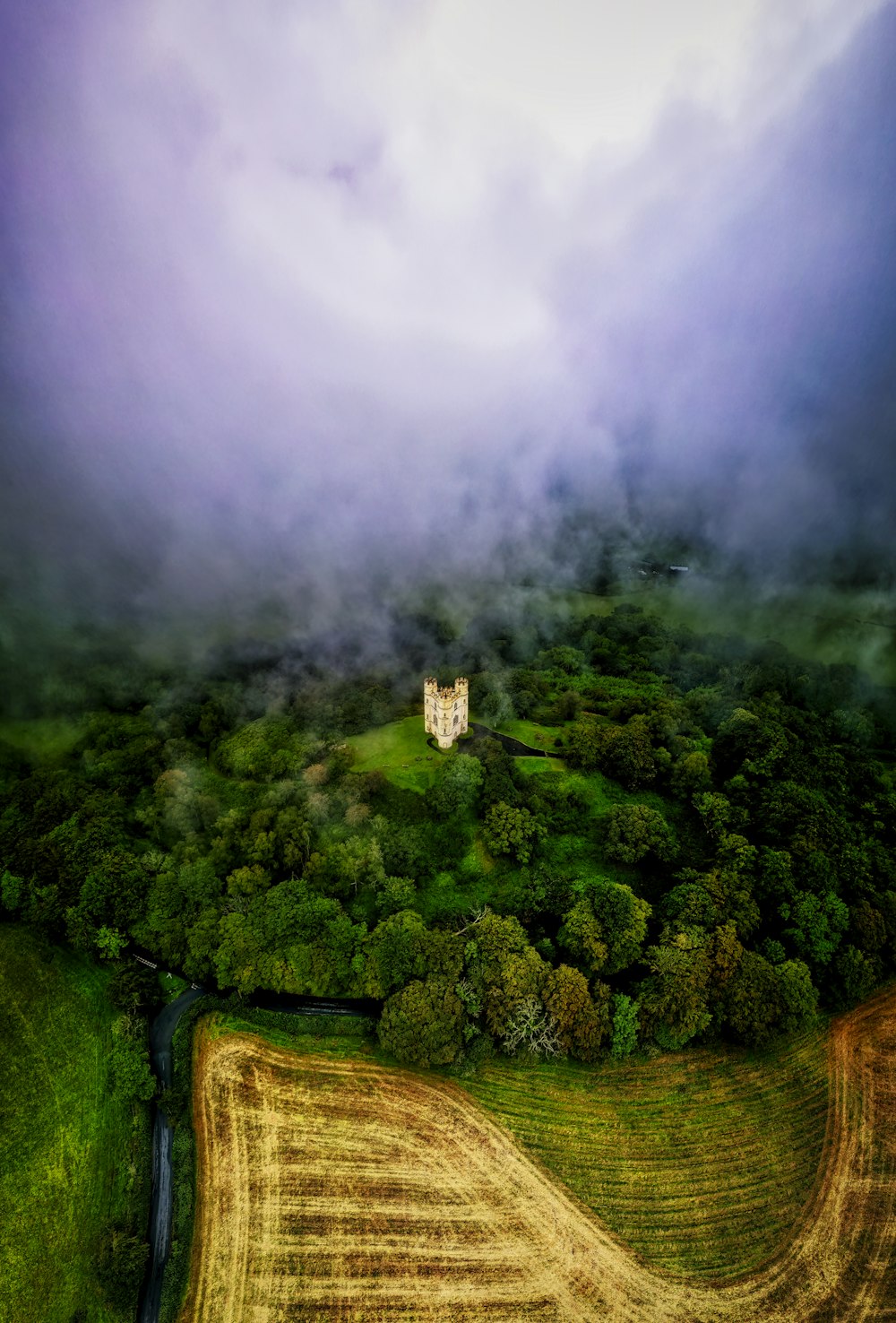 an aerial view of a house in the middle of a field