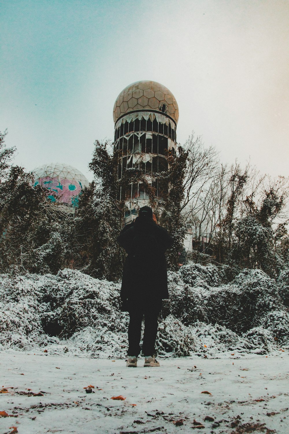 a person standing in the snow in front of a building