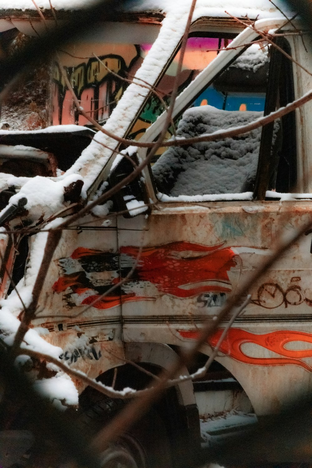 a rusted out van with graffiti on the side of it