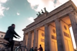 The iconic Brandenburg Gate in Berlin glowing warmly against a twilight sky.