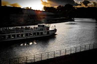 Travelers enjoying a boat ride along the peaceful Thu Bon River at sunset.