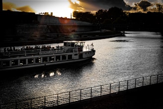 An elegant traveler enjoying a private sunset boat ride on a calm river surrounded by lush greenery.