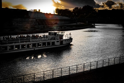 An elegant traveler enjoying a private sunset boat ride on a calm river surrounded by lush greenery.