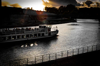 Travelers enjoying a boat ride along the peaceful Thu Bon River at sunset.