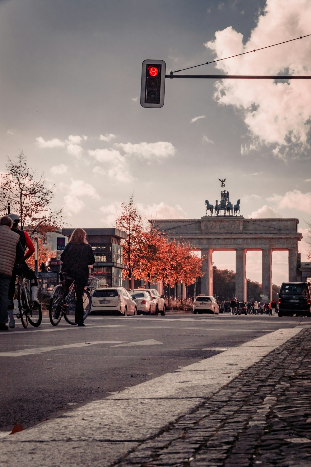 a red traffic light sitting above a street filled with traffic